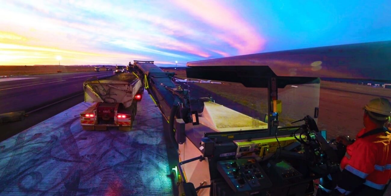 view at sunset from machinery loading bitumen into a dump truck