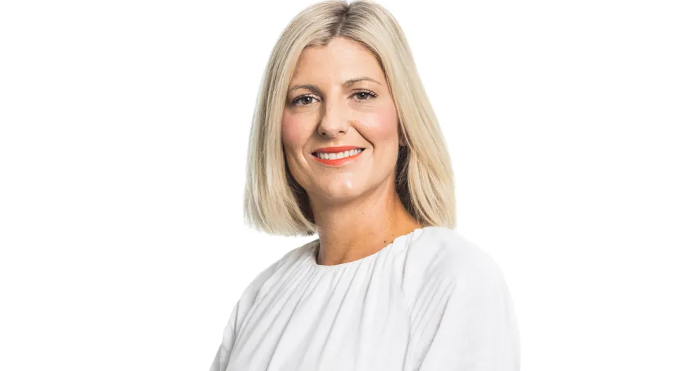Ms Lisa Hewitt wearing a grey suit jacket with blank hems