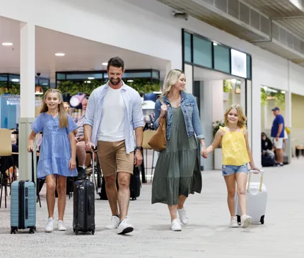 family with suitcases walking through the Townsville airport