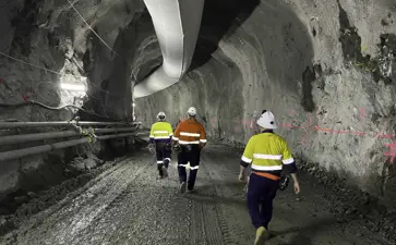 Genex Kidston Pumped Storage Hydro Project NAIF Site Visit With Three Workers Wearing High Vis Walking Down An Tunnel And Pipes