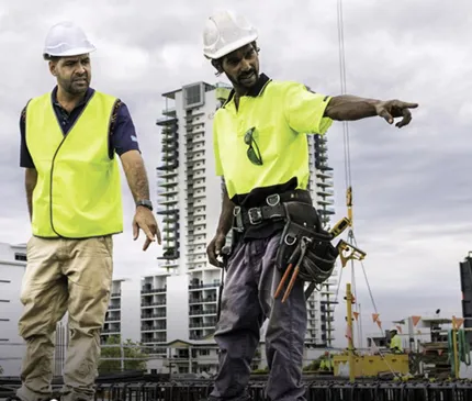 Northern Territory Infrastructure Loans Construction Workers On Rooftop With High Rise In Backrgound on Territory Infrastructure Loans