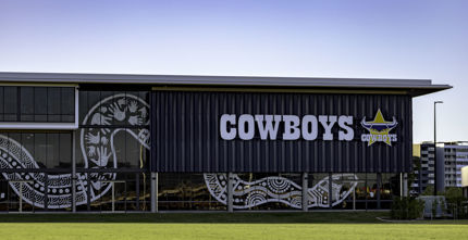 HERO NQ Cowboys Hutchinson Builders Centre front view of exterior with indigenous snake artwork on glass and cowboys logo with grass in the foreground