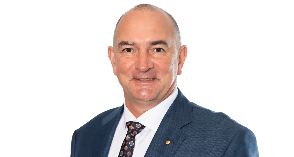 Tracey Hayes wearing a blue top and black blazer on a white background