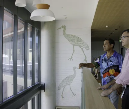 JCU Indigenous Student Support And Traditional Owner Eddie Savage With NAIF Staff Ben Gertz At JCU Halls Of Residence With Ibis Artwork In The Background 