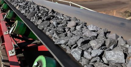 Manganese ore travelling down a conveyor belt